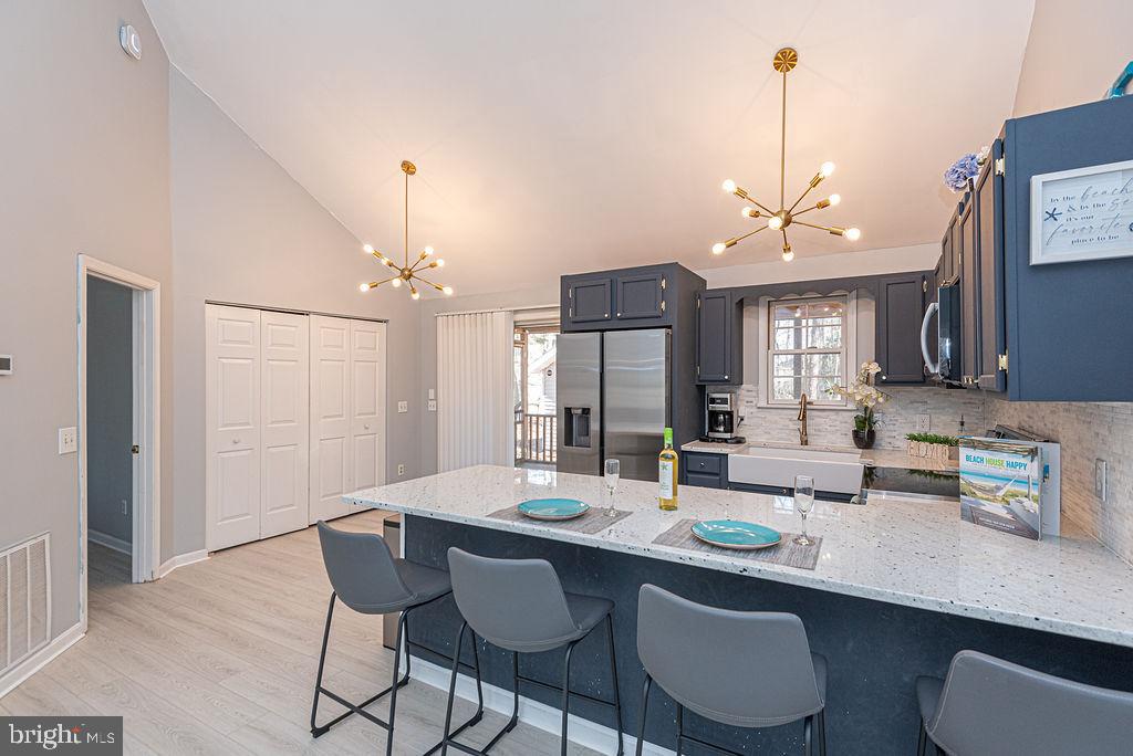 47 Falcon Bridge Road Ocean Pines, MD 21811 - Photo 15 of 78 a kitchen with a dining table chairs and white cabinets
