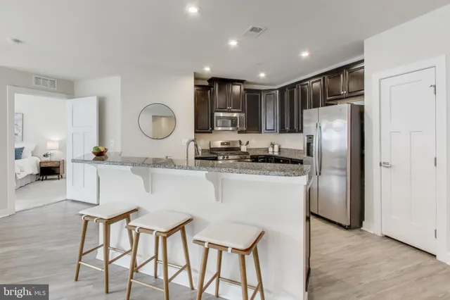 a kitchen with stainless steel appliances granite countertop a refrigerator and a stove top oven