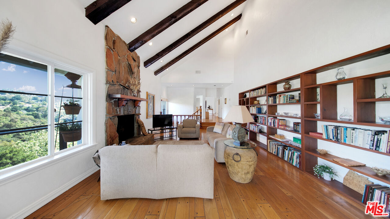 2312 Kimridge Road Beverly Hills, CA 90210 - Photo 21 of 60 a living room with lots of furniture and a book shelf