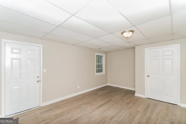 an empty room with wooden floor and windows