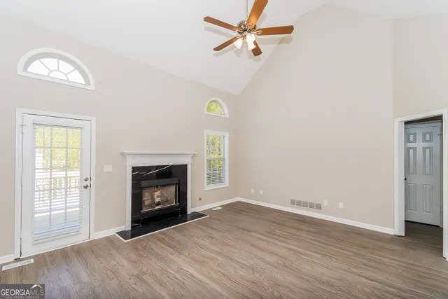 an empty room with windows a fireplace