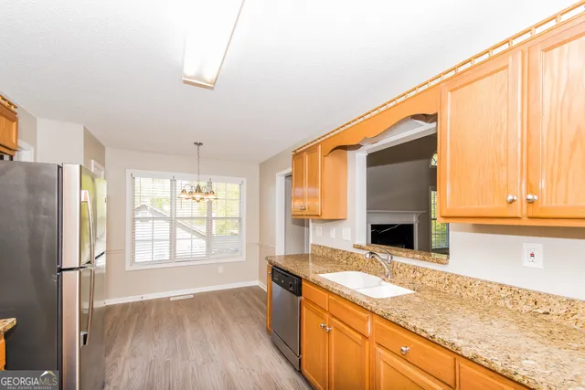 a kitchen with granite countertop a sink and a refrigerator
