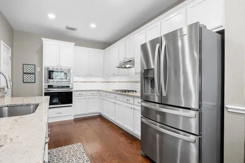 a kitchen with stainless steel appliances a refrigerator sink and cabinets