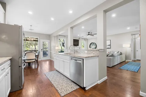 a large kitchen with a lot of counter space and wooden floor
