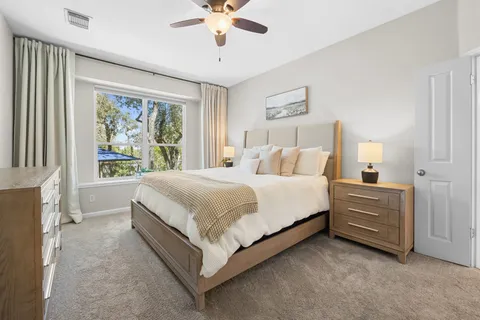 a spacious bedroom with a bed and a chandelier