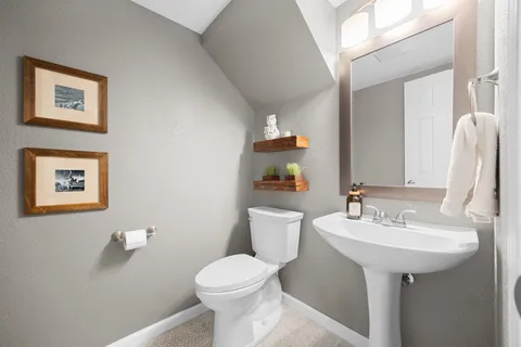 a bathroom with a sink mirror and toilet