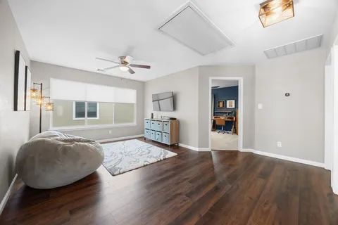 a living room with hardwood floor and a ceiling fan