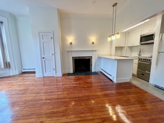 a view of a kitchen with a stove wooden floor kitchen view and a sink