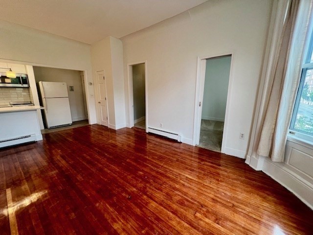 591 Beacon Street, Unit 3 Boston, MA 02215 - Photo 3 of 9 a view of an empty room with wooden floor and a window