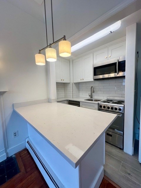591 Beacon Street, Unit 3 Boston, MA 02215 - Photo 8 of 9 a kitchen with kitchen island a stove a sink and a microwave