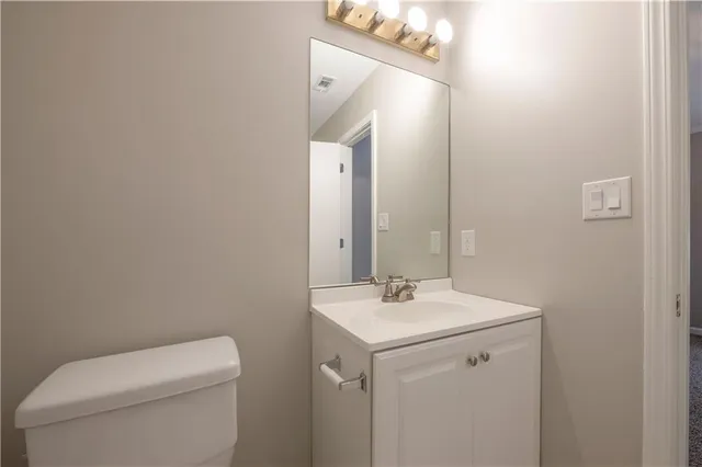 a bathroom with a toilet a sink and mirror