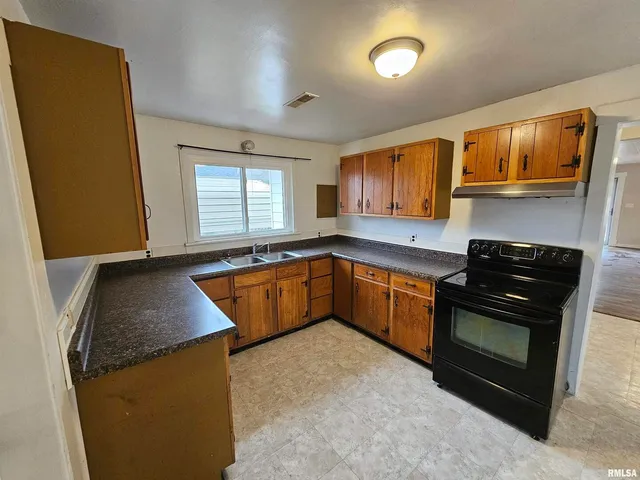 a kitchen with granite countertop a sink stainless steel appliances and cabinets