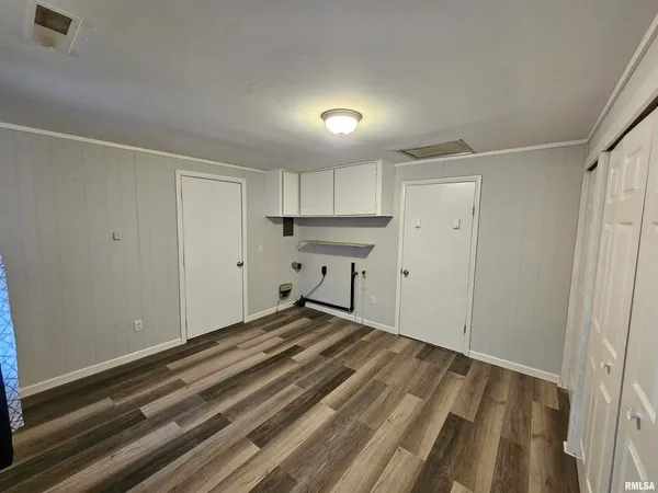 a view of a room with wooden floor and a window