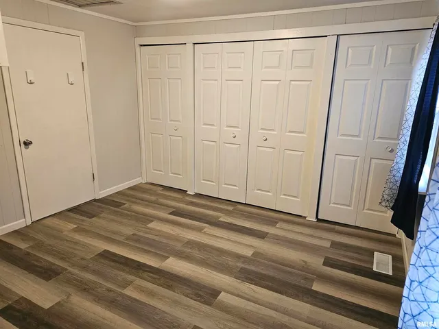 a view of a closet area with hardwood floor
