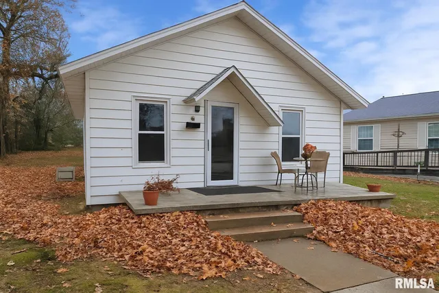 a view of a house with backyard and chairs