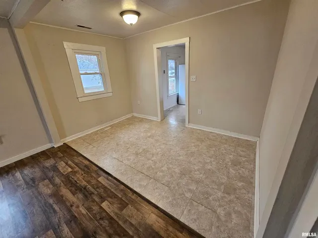 an empty room with wooden floor and closet