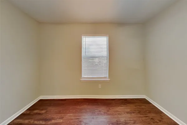 an empty room with wooden floor and a window