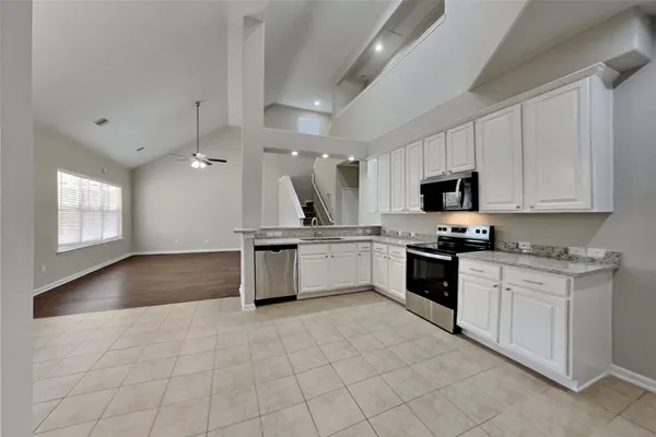 a kitchen with granite countertop a stove sink and cabinets