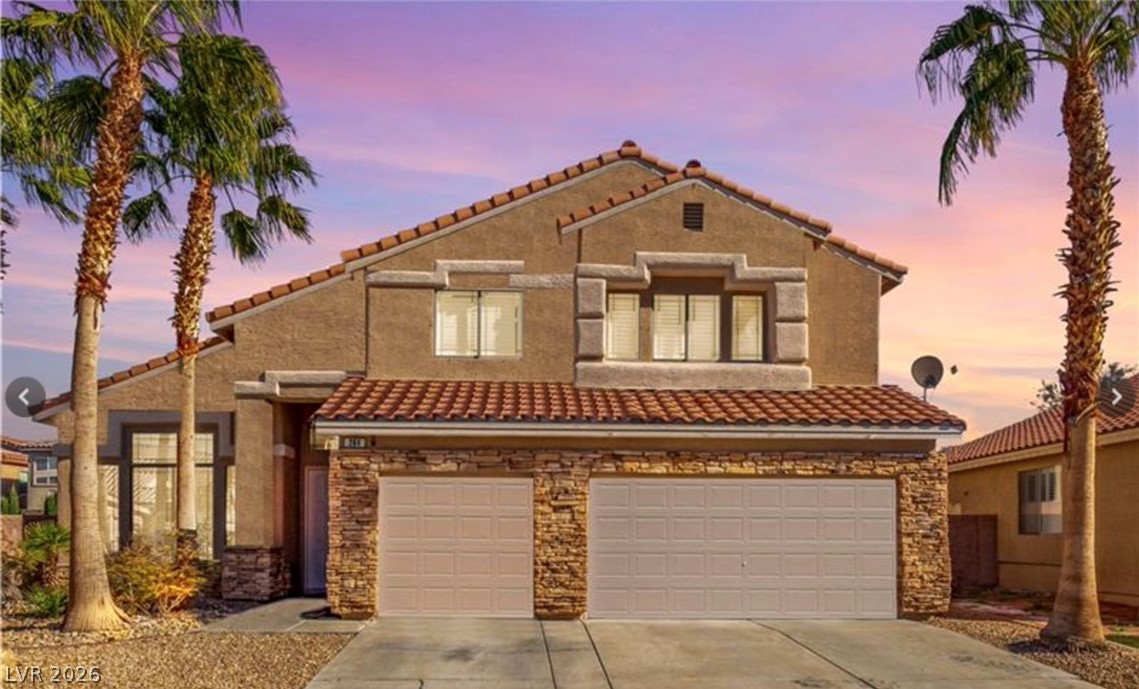 264 Pointe Ranier Avenue Henderson, NV 89012 - Photo 42 of 43 A terracotta-tiled roof crowns this residence with a stone-clad garage under a vibrant desert sky.