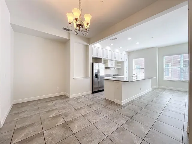 a kitchen with granite countertop a sink and white cabinets