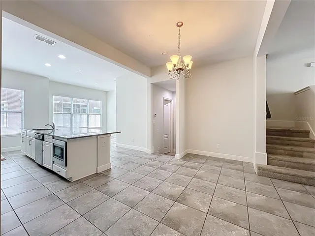 a large kitchen with granite countertop a stove a sink and a refrigerator