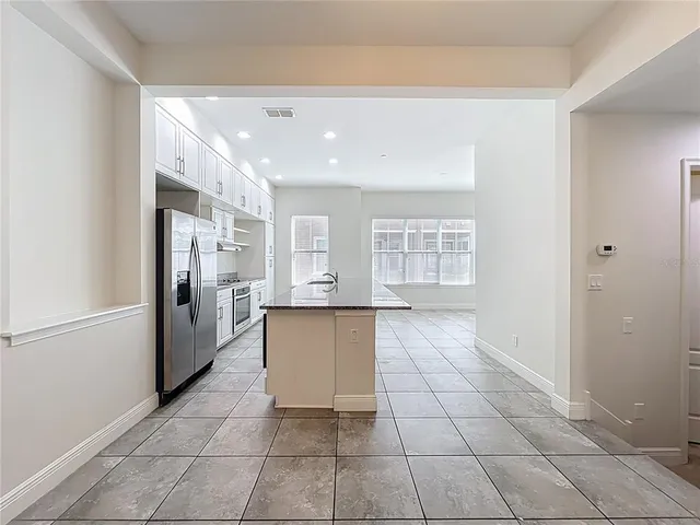 a large kitchen with stainless steel appliances granite countertop a large stove top oven and cabinets