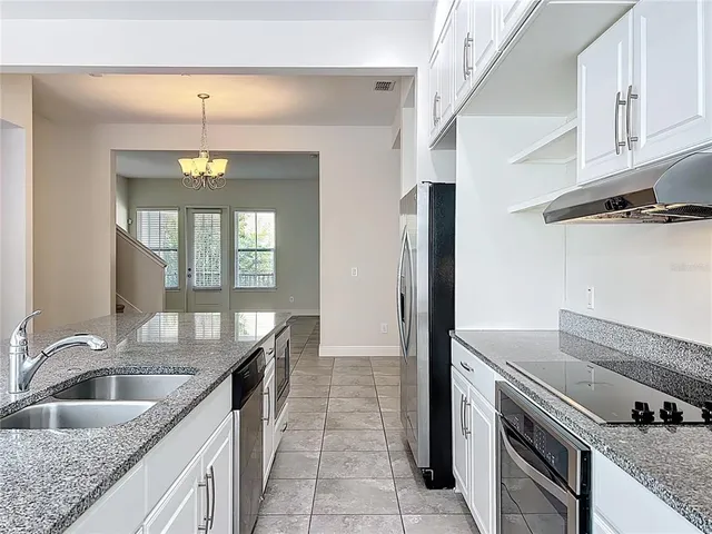a view of a room with a chandelier fan and windows