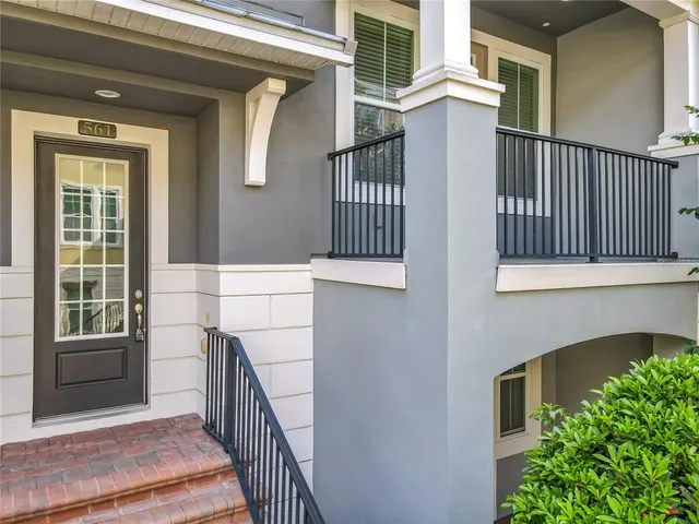 a front view of a house with a window and potted plants