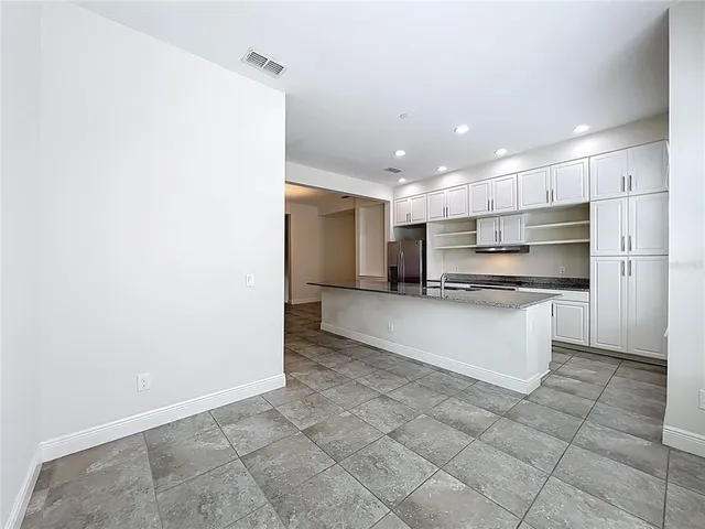 an empty room with ceiling fan and window
