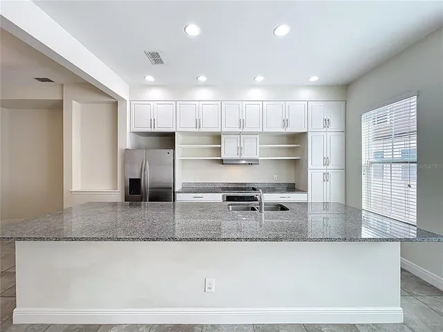 a bathroom with a granite countertop toilet and a sink