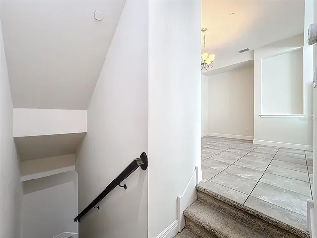 an empty room with a fan & a window