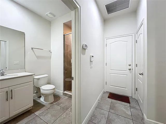a spacious bathroom with a granite countertop sink a toilet and a mirror