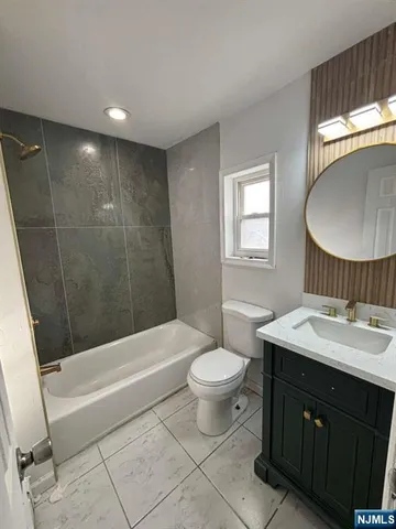 a bathroom with a sink toilet a mirror and bathtub