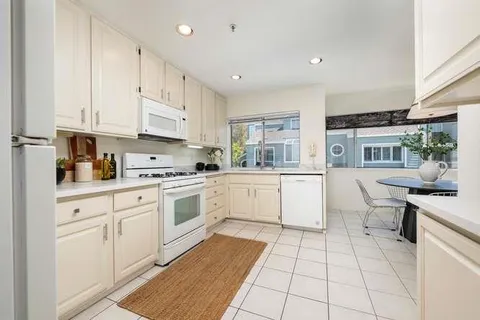 a kitchen with a stove sink and cabinets