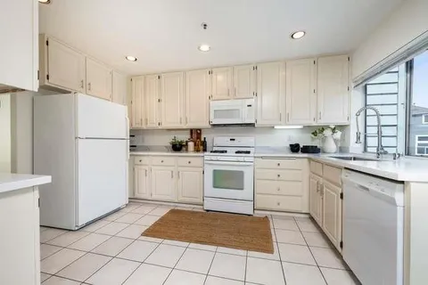 a kitchen with cabinets stainless steel appliances and a window