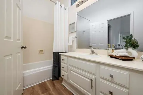 a bathroom with a tub sink and mirror