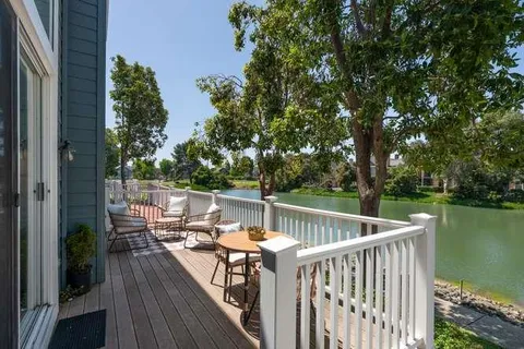 a view of deck with furniture and trees around