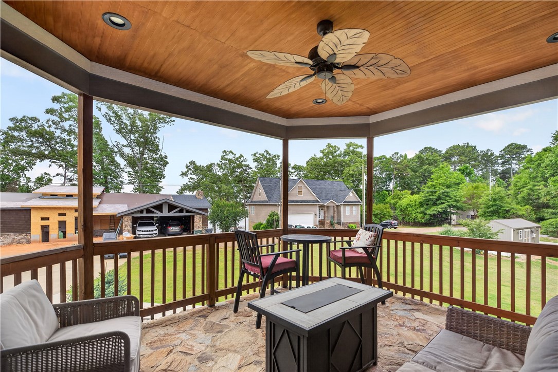 206 James Hare Road Anderson, SC 29626 - Photo 25 of 37 A spacious covered porch features stone flooring, a leaf-bladed ceiling fan, and overlooks the surrounding landscape.