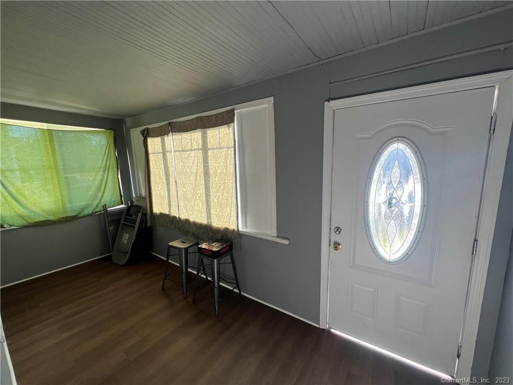 796 Tower Avenue Hartford, CT 06112 - Photo 2 of 9 an empty room with wooden floor mirror and windows