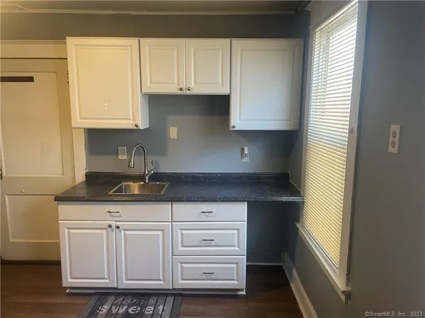 a kitchen with granite countertop a sink and a stove