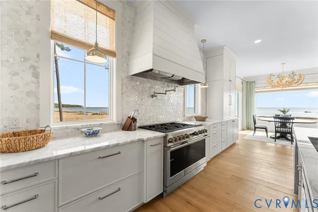 a kitchen with a stove a sink and a wooden floor