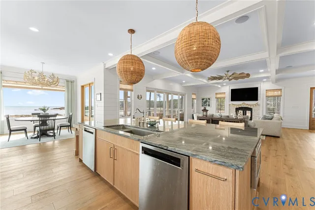 a kitchen with stainless steel appliances granite countertop a stove a sink a dining table and chairs