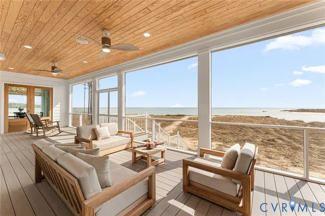 a living room with furniture and floor to ceiling windows