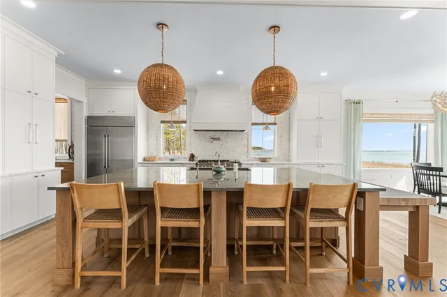a kitchen with stainless steel appliances a dining table chairs and a chandelier
