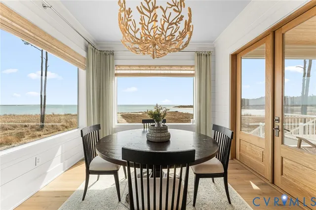 a dining room with furniture large windows and a chandelier