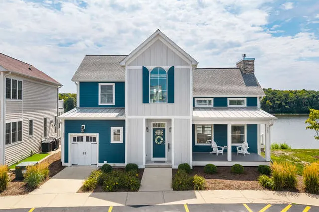 a front view of a house with garden and garage
