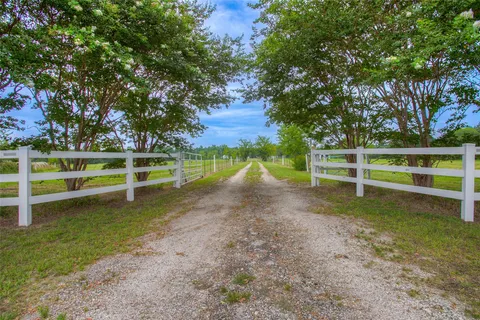 a view of a yard with wooden fence