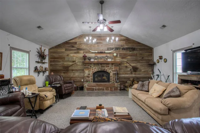 a living room with furniture a fireplace and a chandelier