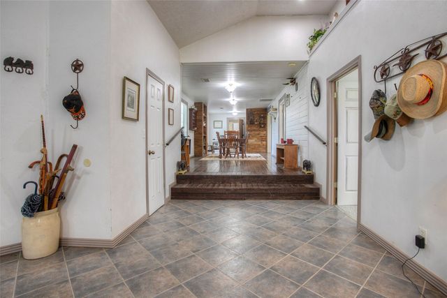 a view of a hallway with wooden floor and furniture