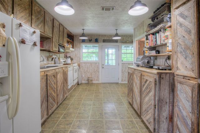 a kitchen with stainless steel appliances granite countertop a sink a stove a refrigerator and cabinets